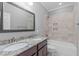 Bathroom with granite countertop, dual sinks, and a tiled shower-tub combination at 1104 Hobson Ct, Raleigh, NC 27607