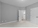 Bedroom featuring neutral carpet and gray walls, with view to laundry room at 1104 Hobson Ct, Raleigh, NC 27607