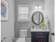 Charming half bath featuring vanity with marble countertop and decorative mirror at 1104 Hobson Ct, Raleigh, NC 27607