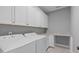 Functional laundry room features white cabinets, countertop space, and modern appliances at 1104 Hobson Ct, Raleigh, NC 27607