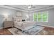 This primary bedroom features a trey ceiling, large windows and an elegant upholstered bed at 1104 Hobson Ct, Raleigh, NC 27607