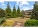 Well-maintained backyard with grass, trees, a stone pathway, and a black iron fence at 1108 Cadence Ln, Durham, NC 27703