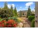 Landscaped backyard featuring beautiful red azaleas, a stone pathway, and a well-maintained lawn at 1108 Cadence Ln, Durham, NC 27703