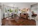 Bright breakfast nook features hardwood floors, a round table, and a stylish wooden cabinet for storage at 1108 Cadence Ln, Durham, NC 27703