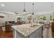Open kitchen with a granite island, stainless sink, and views of the living and dining areas at 1108 Cadence Ln, Durham, NC 27703