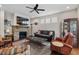 Cozy living room area with stone fireplace, ceiling fan, and comfortable seating at 1108 Cadence Ln, Durham, NC 27703