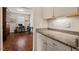 Butler's pantry with granite countertops, and open to office with hardwood flooring and ample storage at 1108 Cadence Ln, Durham, NC 27703