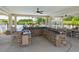 Inviting outdoor kitchen with stone accents, modern countertops and sink overlooking a community pool at 1108 Cadence Ln, Durham, NC 27703