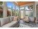 Serene sunroom featuring a cozy sofa, vaulted ceiling, and an abundance of natural light from all the windows at 1108 Cadence Ln, Durham, NC 27703