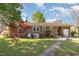 Spacious backyard with a brick house, green lawn, a paved walkway, and a beautiful, red maple tree at 1108 Friendly Rd, Dunn, NC 28334