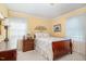 Bright bedroom with floral bedding, two windows with natural light, and a bedside table at 1108 Friendly Rd, Dunn, NC 28334