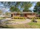 A well-maintained single-story brick home with a lush green lawn and curved sidewalk at 1108 Friendly Rd, Dunn, NC 28334