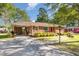 Brick home with a cozy covered carport and neat landscaping leading up to a quaint red door at 1108 Friendly Rd, Dunn, NC 28334
