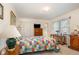 Relaxing bedroom featuring a quilted bed, dresser with a TV, and a window view at 1108 Friendly Rd, Dunn, NC 28334