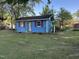 Bright blue outbuilding with red trim in a green lawn, perfect for storage or a creative space at 1108 Friendly Rd, Dunn, NC 28334