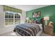 Inviting bedroom with a large window, green accent wall, and modern decor at 1109 Ursa Major Ct, Wendell, NC 27591