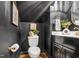 Moody half bathroom with black walls, golden hardware, and modern fixtures at 1113 Colonial Club Road Rd, Wake Forest, NC 27587
