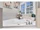 A close-up of a soaking tub with silver fixtures and a window with a plant, tile detailing, and decorations at 1113 Colonial Club Road Rd, Wake Forest, NC 27587