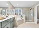 Modern bathroom featuring a tub, a sleek shower, double sinks, updated fixtures and plenty of natural light at 1113 Colonial Club Road Rd, Wake Forest, NC 27587