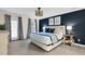 Bright bedroom with carpet and blue accent wall; features a king bed, stylish curtains, modern lighting, and wall art at 1113 Colonial Club Road Rd, Wake Forest, NC 27587