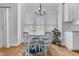 Cozy dining area with a round table, four chairs, chandelier, and natural light from large windows at 1113 Colonial Club Road Rd, Wake Forest, NC 27587