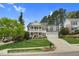 Classic two-story home with a double front porch, attached garage, and mature trees in a landscaped yard at 1113 Colonial Club Road Rd, Wake Forest, NC 27587