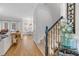 Inviting foyer with hardwood floors and a staircase featuring carpeted steps and decorative floral arrangement at 1113 Colonial Club Road Rd, Wake Forest, NC 27587