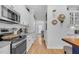 Kitchen boasts stainless steel appliances, white cabinets, subway tile backsplash, and hardwood floors at 1113 Colonial Club Road Rd, Wake Forest, NC 27587
