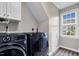 Bright laundry room with modern, front load washer and dryer, and wood flooring at 1113 Colonial Club Road Rd, Wake Forest, NC 27587