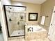 Bright bathroom featuring a glass enclosed shower and separate tub with tile surround at 1114 Glenolden Ct, Cary, NC 27513
