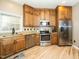 Updated kitchen boasts stainless steel appliances, light wood floors, wood cabinetry, and granite counters at 1114 Glenolden Ct, Cary, NC 27513