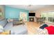 Spacious living room with hardwood floors, blue accent wall, fireplace, sectional sofa, and lots of natural light at 1114 Glenolden Ct, Cary, NC 27513