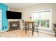 Living room with a fireplace, mounted TV, table, and window, providing a cozy and inviting space at 1114 Glenolden Ct, Cary, NC 27513