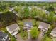 Aerial view of a two-story brick home with a well-maintained lawn, surrounded by mature trees in a quiet neighborhood at 112 Mendells Dr, Holly Springs, NC 27540