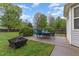 Outdoor patio with furniture and a fire pit surrounded by lush greenery, perfect for entertaining at 112 Mendells Dr, Holly Springs, NC 27540