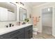 Modern bathroom with double sinks, dark cabinets, and stylish fixtures offers a sleek and functional space at 112 Mendells Dr, Holly Springs, NC 27540