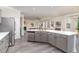 Modern kitchen with a large island, grey cabinets, stainless steel appliances, and open concept to the living area at 112 Mendells Dr, Holly Springs, NC 27540