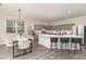 Modern kitchen with a large island, grey cabinets, stainless steel appliances, and adjacent dining area at 112 Mendells Dr, Holly Springs, NC 27540