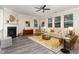 Inviting living room featuring a cozy fireplace, hardwood floors, lots of natural light, and modern furnishings at 112 Mendells Dr, Holly Springs, NC 27540