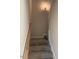 Carpeted staircase featuring a wood handrail and modern lighting at 112 Surles Landing Way, Benson, NC 27504