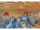 Unfinished attic space shows wooden beams, exposed insulation, and offers potential for customization at 115 Windy Creek Ln, Apex, NC 27502