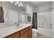 Well-lit bathroom features a single sink vanity, bath tub with shower, and modern fixtures at 115 Windy Creek Ln, Apex, NC 27502