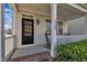 Inviting front porch featuring a classic black door and comfortable rocking chairs at 115 Windy Creek Ln, Apex, NC 27502