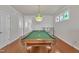 Well-lit game room featuring a pool table, stylish lighting, and hardwood floors at 115 Windy Creek Ln, Apex, NC 27502