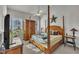Spacious main bedroom features a four-poster bed, plenty of natural light, and ample storage space at 115 Windy Creek Ln, Apex, NC 27502