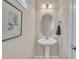 Elegant powder room with pedestal sink, decorative mirror, and neutral wall color offers a charming space at 115 Windy Creek Ln, Apex, NC 27502