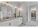 Bathroom featuring double vanities, decorative mirrors, and a walk-in closet at 116 Palermo Ct, Apex, NC 27539