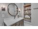 Well-lit bathroom features a round mirror, floating shelves, and a vanity with modern fixtures at 116 Palermo Ct, Apex, NC 27539