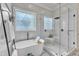 Bright bathroom featuring a soaking tub, glass shower, and decorative privacy windows providing ample natural light at 116 Palermo Ct, Apex, NC 27539