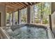 Tranquil outdoor hot tub on a covered patio with a view of the wooded backyard at 116 Palermo Ct, Apex, NC 27539